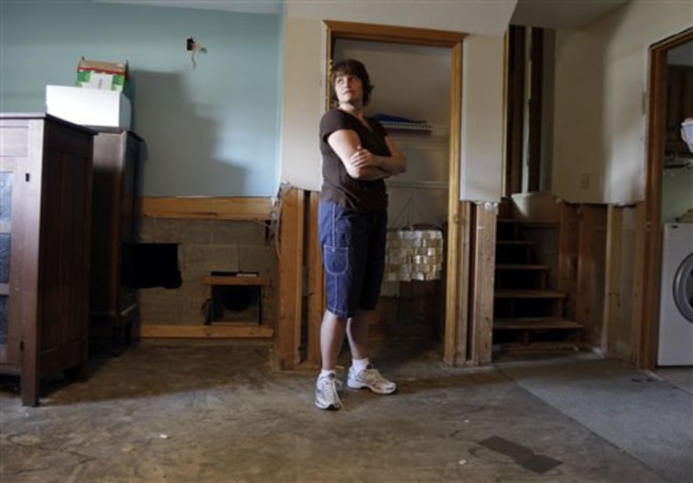 Kellie DeVault looks over a flood-damaged basement in Greenwood, Ind., on Aug. 18. DeVault and her family are moving out of the damaged home and are seeking a buyout for the damaged property. 
